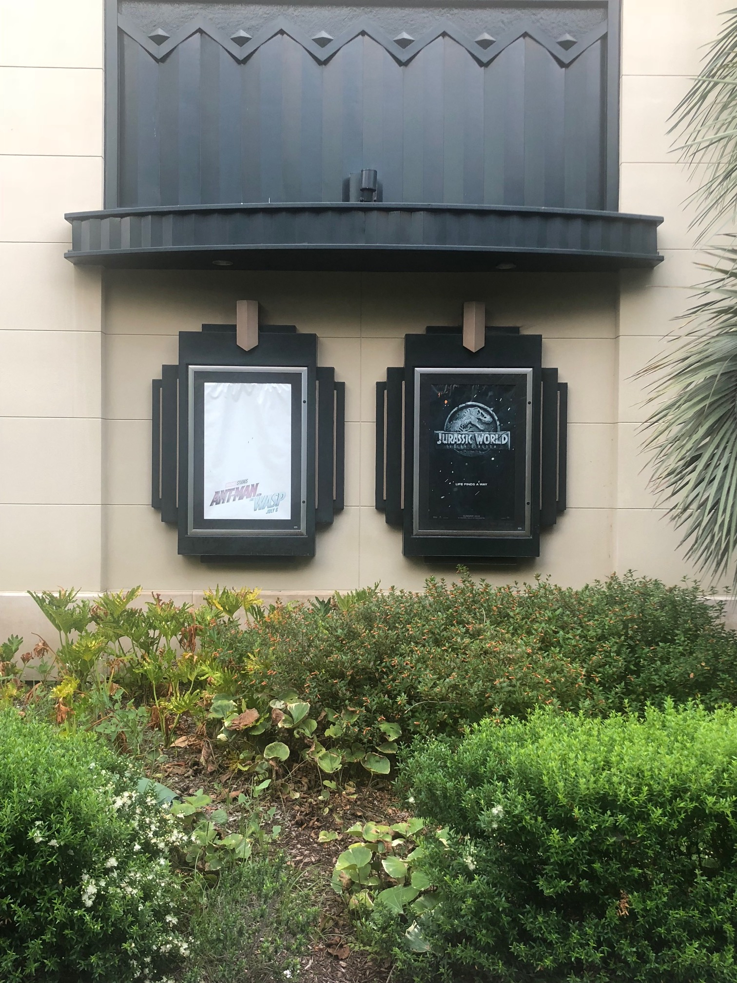 In contrast to new banners and construction on the north side of the AMC Theater, sun-bleached posters can be seen on the west end of the building.